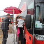 Daniella Hundscheid krijgt begeleiding om het de lunchboxes 'regenvrij' in de IBA-bus te serveren.